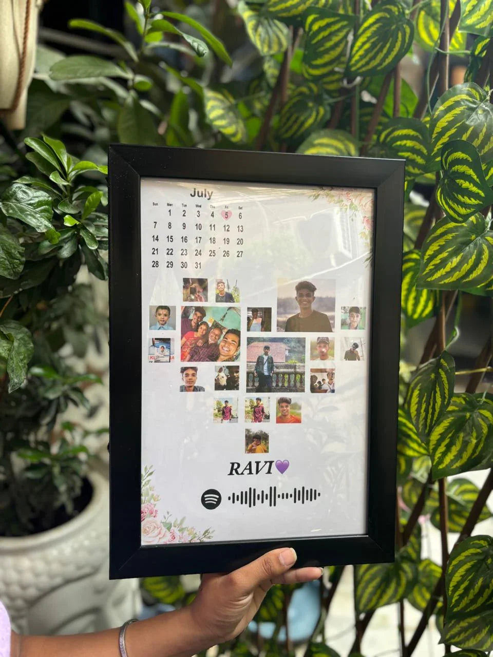 Personalized photo calendar with July dates, name RAVI, Spotify code, and collage photos in black frame