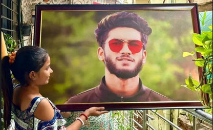 Girl holding framed portrait of man in red sunglasses, perfect personalized gift idea